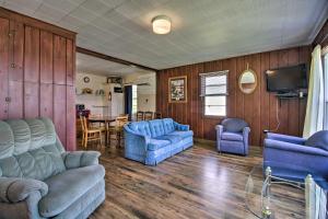 a living room with blue couches and a kitchen at Pet-Friendly Beachfront Dent Cabin w/ Grill! in Dent