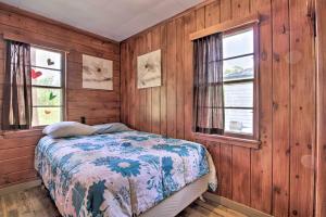 a bedroom with wooden walls and a bed in a room with windows at Pet-Friendly Beachfront Dent Cabin w/ Grill! in Dent