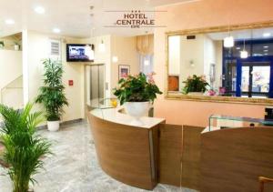 eine Lobby eines Hotels mit Topfpflanzen und einem Spiegel in der Unterkunft Hotel Centrale in Este
