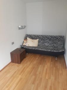 divano nero in camera con pavimento in legno di Atmodas studio a Liepāja