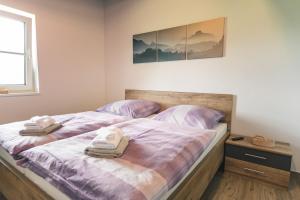 ein Schlafzimmer mit einem Bett mit zwei Handtüchern darauf in der Unterkunft Alpin Lodge Kitzblick in Piesendorf