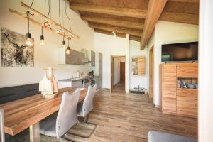 - une salle à manger avec une table et des chaises en bois dans l'établissement Alpin Lodge Kitzblick, à Piesendorf