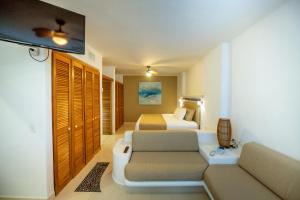 um quarto de hotel com duas camas e um sofá em Las Villas Akumal em Akumal