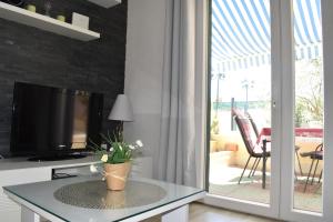 a living room with a tv and a table with a plant at Tamaris in Sevid