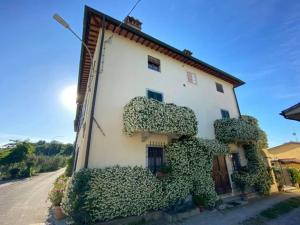 un bâtiment blanc avec des plantes vertes dans l'établissement Borgo dei Cadolingi, à Gambassi Terme