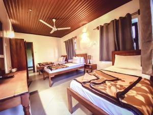 a hotel room with two beds and a ceiling at Smiles Stone Town Hotel in Zanzibar City