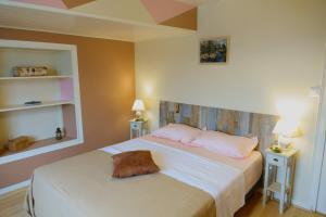 um quarto com uma cama grande e almofadas cor-de-rosa em AU COEUR DU MARAIS em Saint-Hilaire-la-Palud