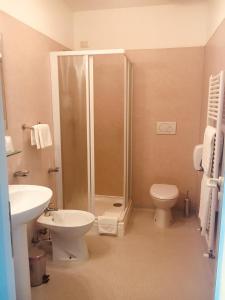 a bathroom with a shower and a toilet and a sink at Hotel Affittacamere alla Posta in San Giórgio di Nogaro