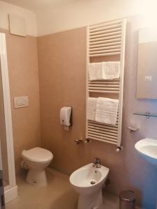 a bathroom with a toilet and a sink at Hotel Affittacamere alla Posta in San Giórgio di Nogaro