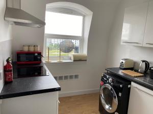 uma cozinha com uma máquina de lavar roupa e uma janela em Serviced Property Apartment em Plymouth