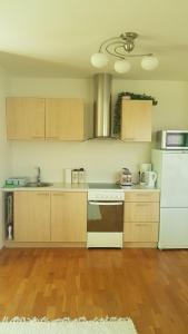 a kitchen with wooden floors and a white refrigerator at Juuli apartament in Kuressaare