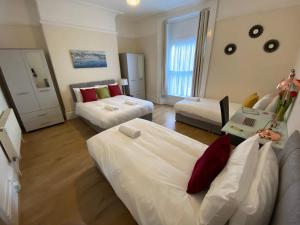 a hotel room with two beds and a couch at Serviced Property Apartment 1 in Plymouth