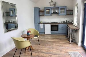 
a kitchen with a table, chairs and a refrigerator at Tigh Noor - Escape to Kinvara by the sea! in Galway
