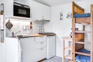 une petite cuisine avec un évier et un micro-ondes dans l'établissement Cosy stay in southern Malmo, à Malmö 6 autres photos