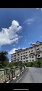 un gran edificio de apartamentos al lado de una carretera en Cameron Highland Cozy Homestay en Tanah Rata