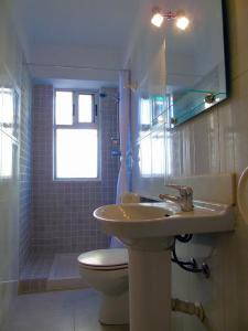 サロウにあるApartamento Miramarのバスルーム(洗面台、トイレ付)、窓が備わります。