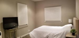 a bedroom with a bed and a flat screen tv at Remodeled Cottage in Berkeley/Oakland Rockridge in Oakland