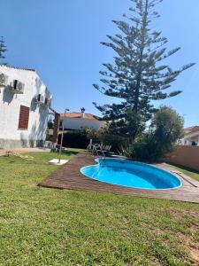 una pequeña piscina en un patio con un árbol en Villa María Elena, en Fuente del Gallo, en Conil de la Frontera