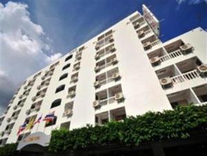 a large white building with balconies on top of it at Nice Palace Hotel in Bangkok