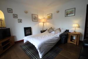 a bedroom with a white bed and a television at The Wee Nook Birnam in Birnam
