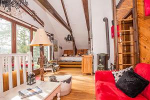 uma sala de estar com um sofá vermelho e uma mesa em chalet la colline em Lans-en-Vercors