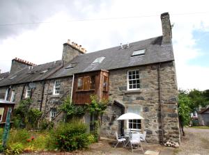 an old stone house with a table and chairs outside at The Wee Nook Birnam in Birnam