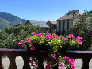 Um ramo de flores cor-de-rosa sentado num banco. em Apartaments La Bonaigua em Valencia de Aneu