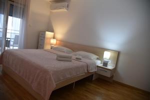 a bedroom with a bed with two towels on it at Apartment Lux Fontana in Budva