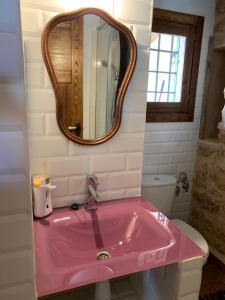 lavabo rosa en el baño con espejo en Casa Rural Ladrón de Semillas, en Elche de la Sierra