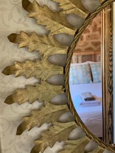 a mirror hanging on a wall next to a bed at Casa Rural Ladrón de Semillas in Elche de la Sierra