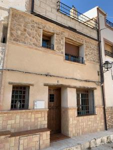 a stone building with a wooden door and windows at Casa Rural Ladrón de Semillas in Elche de la Sierra