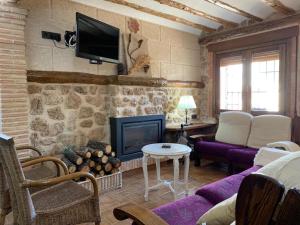 a living room with a couch and a fireplace at Casa Rural Ladrón de Semillas in Elche de la Sierra