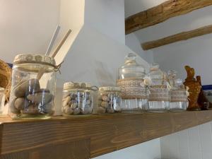 a shelf with glass jars and rocks on it at Casa Rural Ladrón de Semillas in Elche de la Sierra