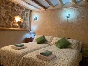 a bedroom with a bed with green pillows on it at Casa Rural Ladrón de Semillas in Elche de la Sierra