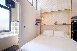 um quarto com uma cama branca e uma janela em Fabulous studio in Châtelain area with balcony em Bruxelas