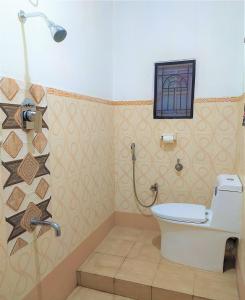 een badkamer met een toilet en een douche bij Criston Home stay in Madurai