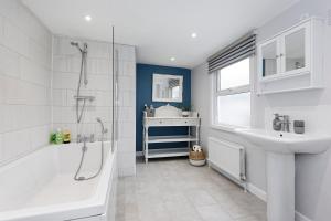 une salle de bain avec une baignoire douche et un lavabo dans l'établissement Pepperpot Cottage, à Whitstable 19 autres photos