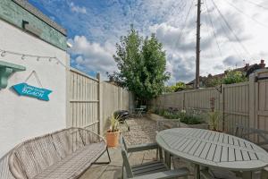 a patio with a table and chairs and a fence at Pepperpot Cottage in Whitstable