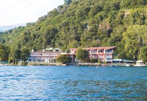a hotel on the shore of a lake with a mountain at Hotel L'Approdo in Pettenasco