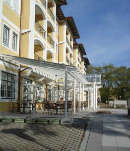 un bâtiment avec des tables et des chaises devant lui dans l'établissement Bad Füssing - Europa Residenz Suite 317 und Big Suite 307, à Bad Füssing