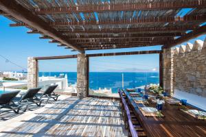 a patio with a table and chairs and a view at Villa Boufla in Agios Ioannis Mykonos