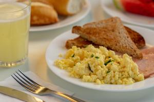 a plate of eggs and toast and a glass of water at ibis budget SP Frei Caneca in Sao Paulo