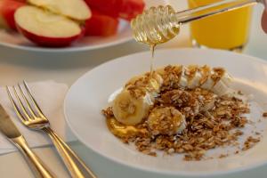 a plate of food with bananas and granola with syrup at ibis budget SP Frei Caneca in Sao Paulo