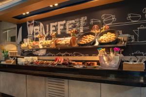 a buffet line with bread and pastries on display at ibis budget SP Frei Caneca in Sao Paulo