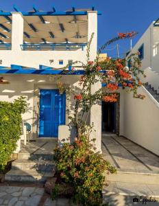a house with a blue door and some flowers at Lina studios in Kalymnos