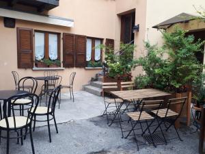 a patio with tables and chairs in front of a building at B&B appartamenti chez Patty in Castel San Pietro