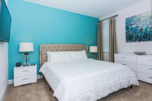 a bedroom with a white bed and blue walls at Gorgeous Single Home with Private Pool at Encore Resort EC7463 in Orlando