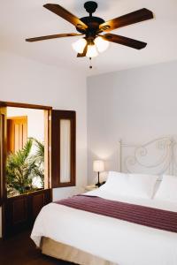 a bedroom with a bed with a ceiling fan at Hotel La Casona de Don Jorge in Colima