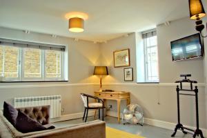 a living room with a couch and a desk and windows at City Studios in Ely