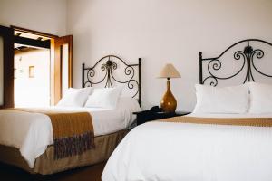 a bedroom with two beds and a mirror at Hotel La Casona de Don Jorge in Colima